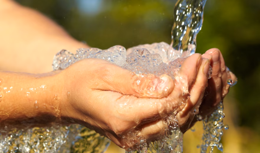 Prélèvement manuel d'eau courante à des fins d'analyse de la qualité de l'eau et d'étude environnementale.