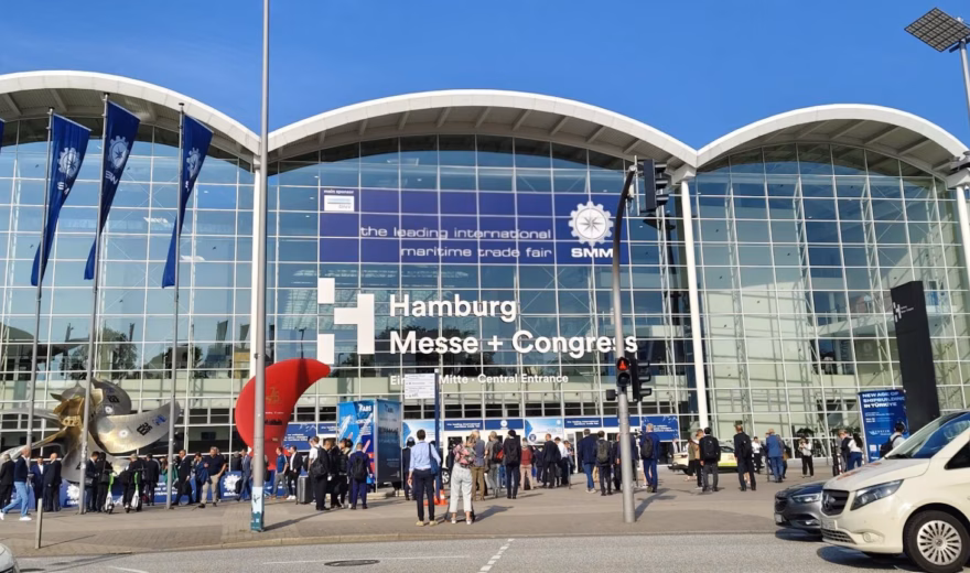 Bezoekers staan voor de ingang van het Hamburg Messe und Congress beurscomplex.