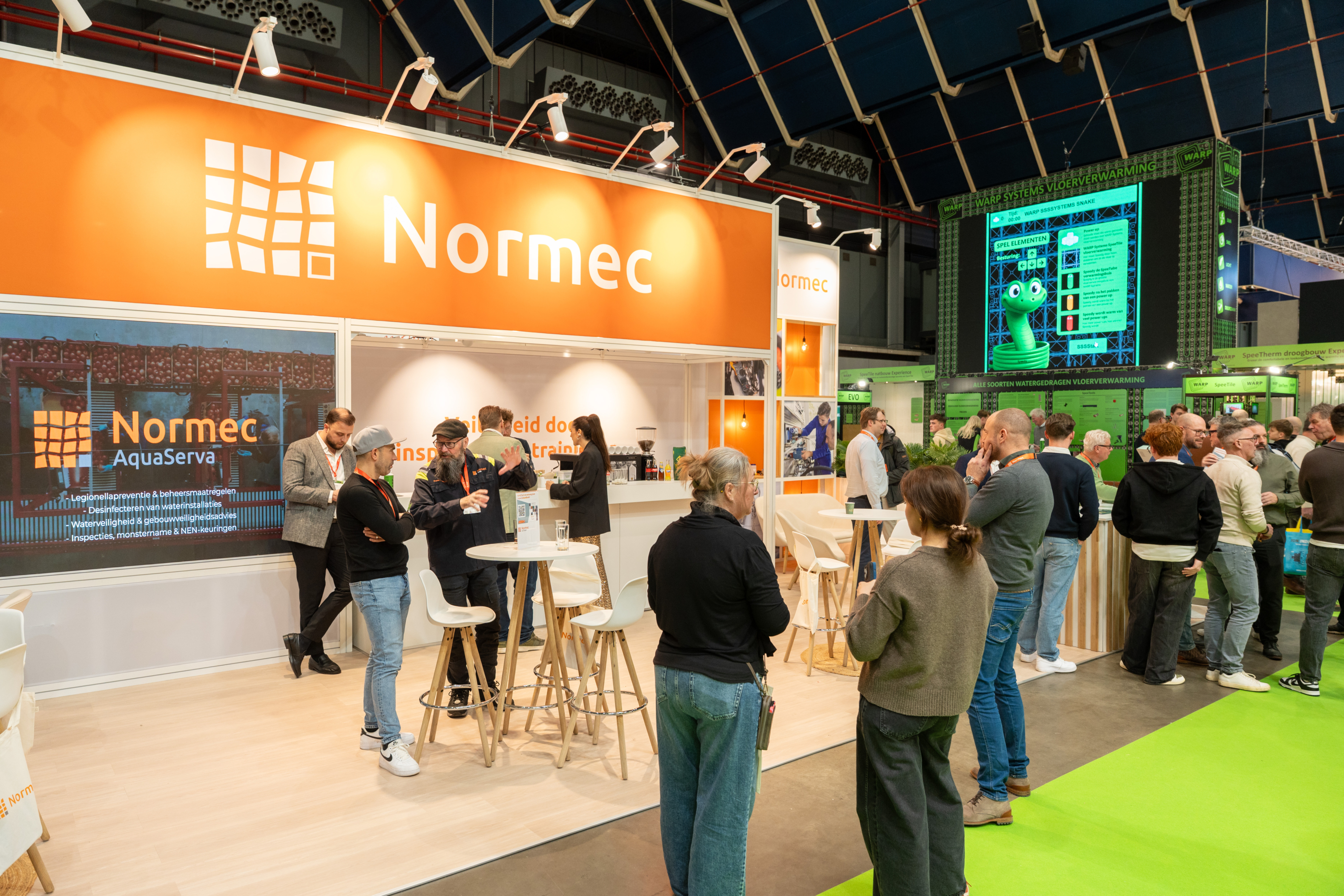 Le stand Normec avec des visiteurs lors d'un salon professionnel ou d'un événement