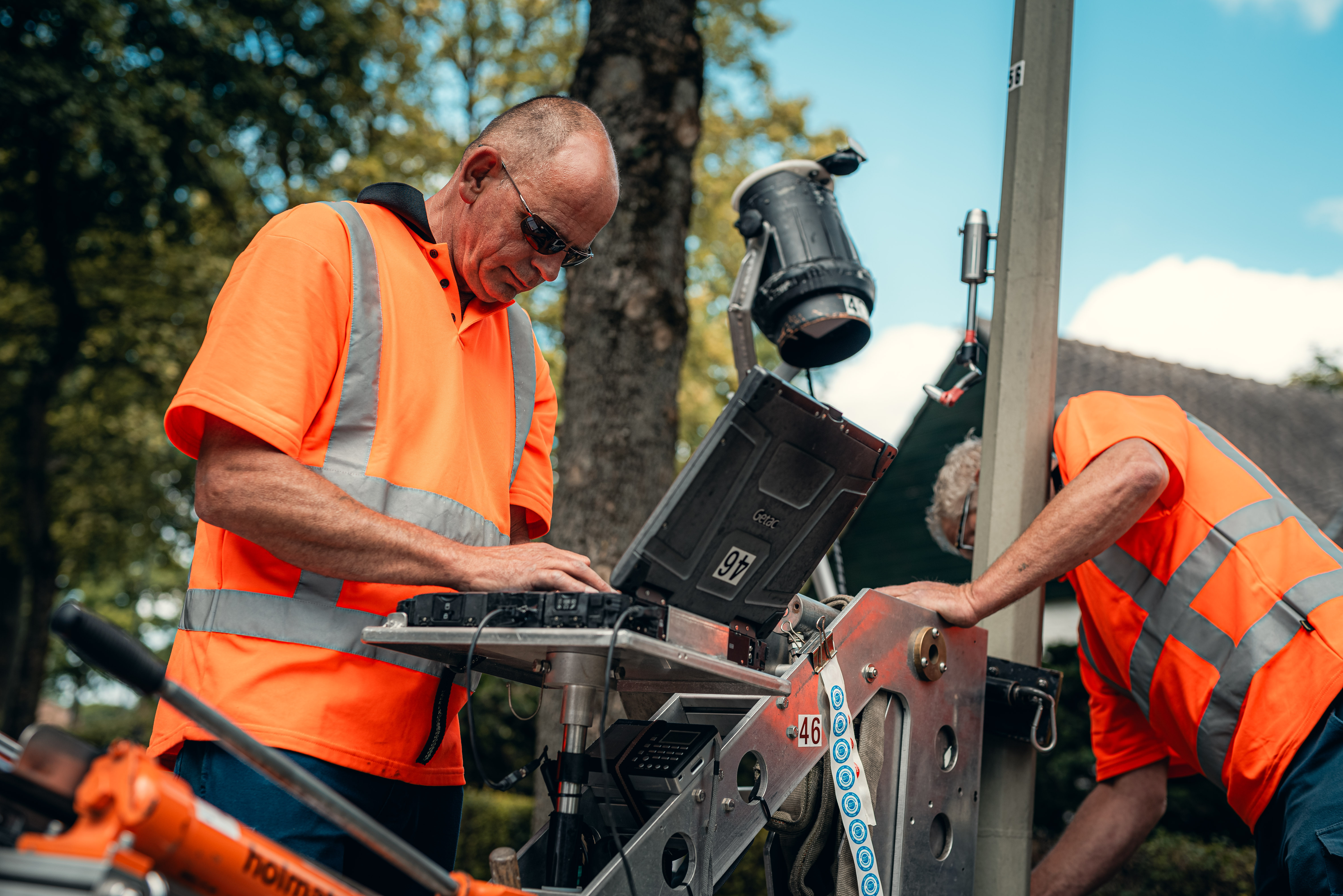Two technicians are performing maintenance work on a technical system on site.
