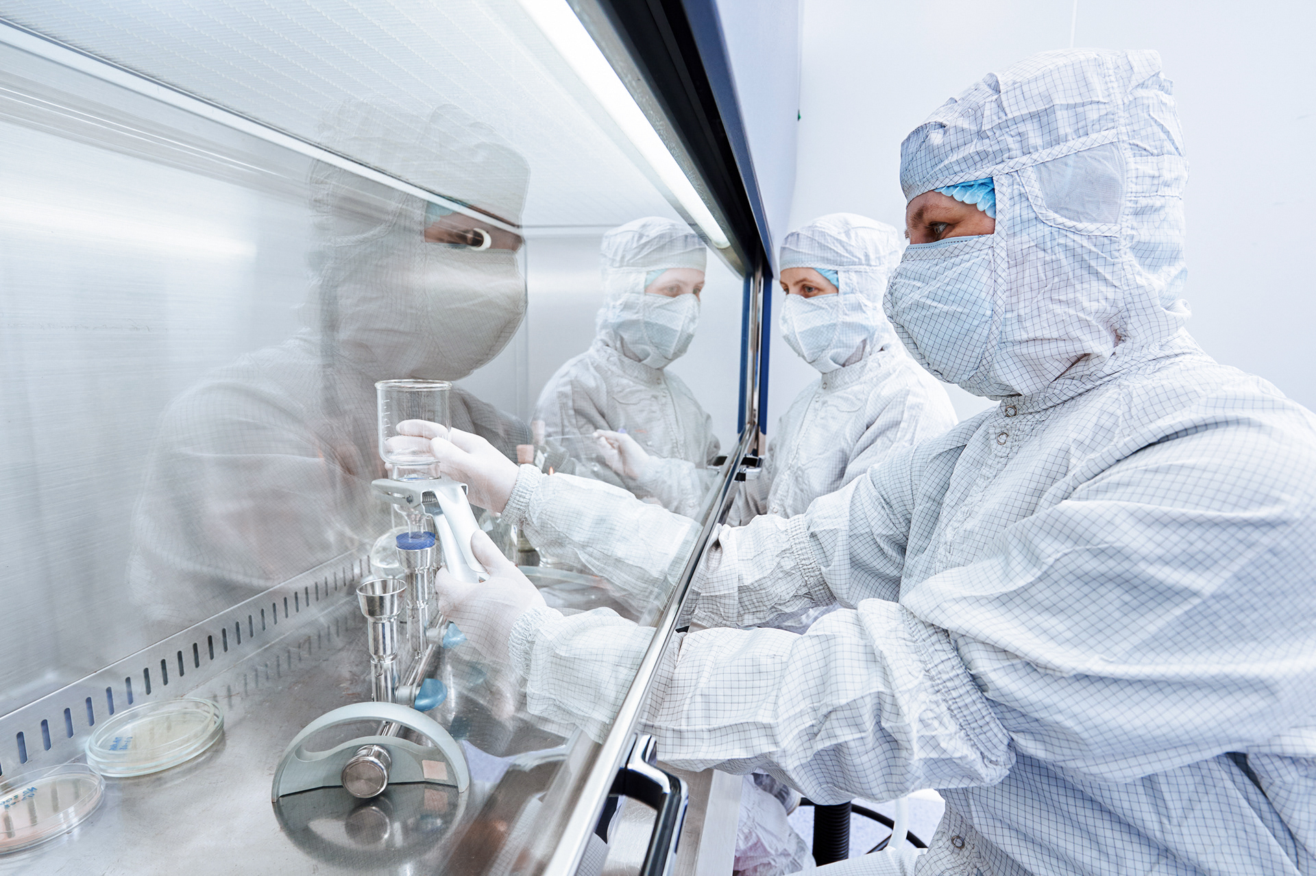 female science researchers in protective uniform and equipment works with dangerous hazard virus material at microbilogy laboratory