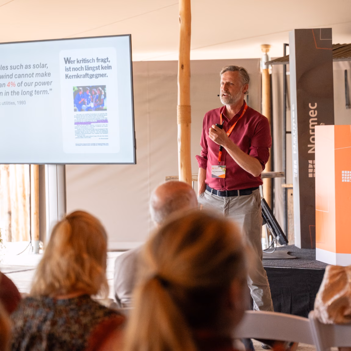 A speaker delivers a presentation to an audience during a professional food industry seminar, with presentation slides displayed on a screen, highlighting food safety, quality assurance, regulatory compliance, industry insights, and knowledge sharing among food sector professionals.