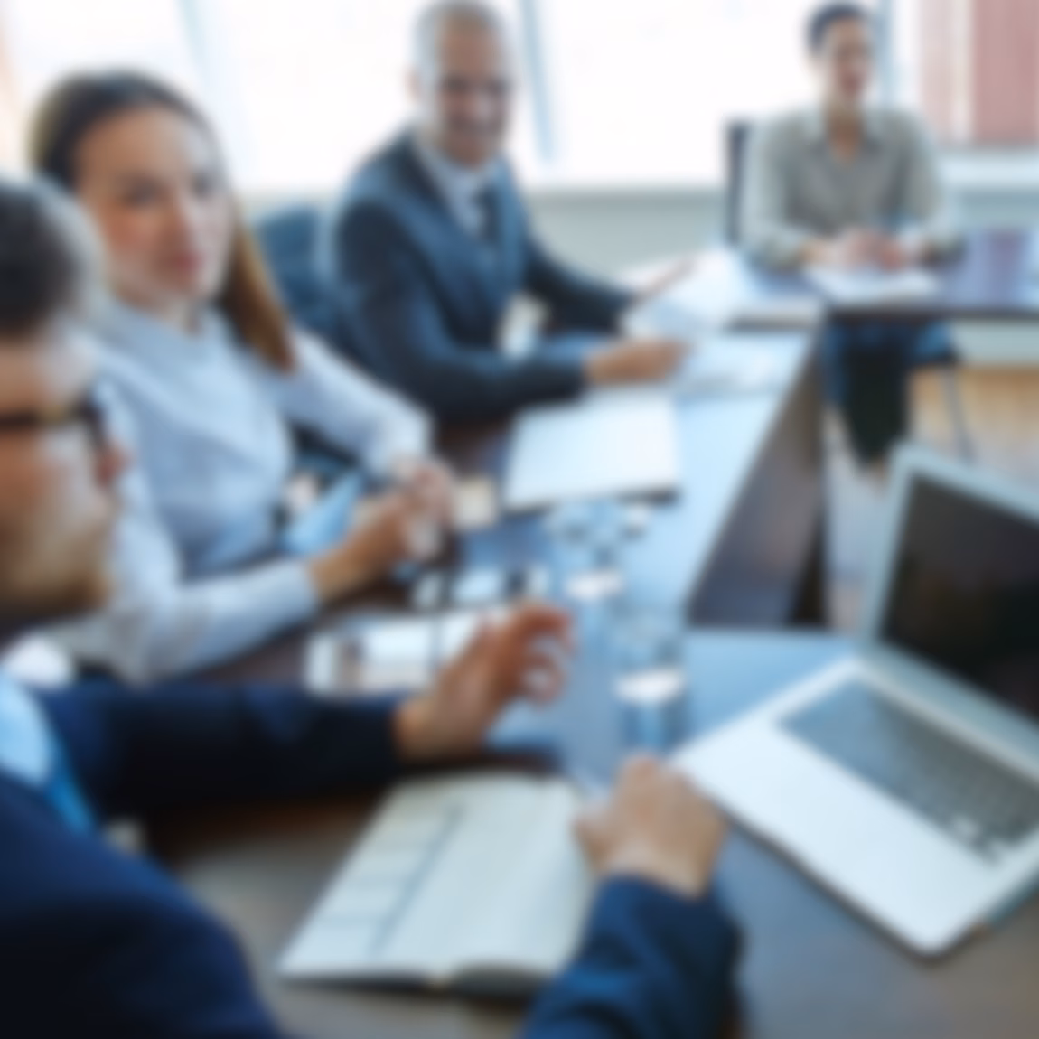 Fachleute nehmen an einer Besprechung am Konferenztisch teil, ausgestattet mit Laptops und Unterlagen. Im Vordergrund stehen Unternehmensberatung, strategische Planung, Einbindung von Interessengruppen, Projektmanagement und effektive Teamarbeit im Unternehmensumfeld.