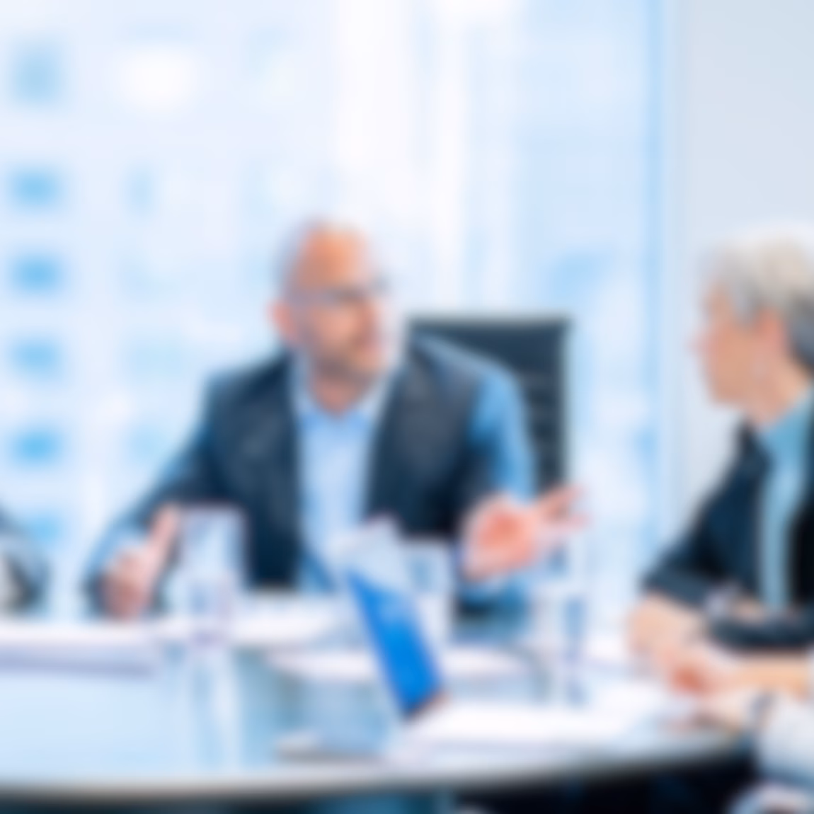 Geschäftsleute nehmen an einer Besprechung am Konferenztisch teil und diskutieren über Strategie, Leistung und Geschäftsziele. Dabei stehen die Zusammenarbeit der Führungskräfte, die Unternehmensführung, die Entscheidungsfindung und professionelle Beratungsdienstleistungen in einer modernen Büroumgebung im Vordergrund.