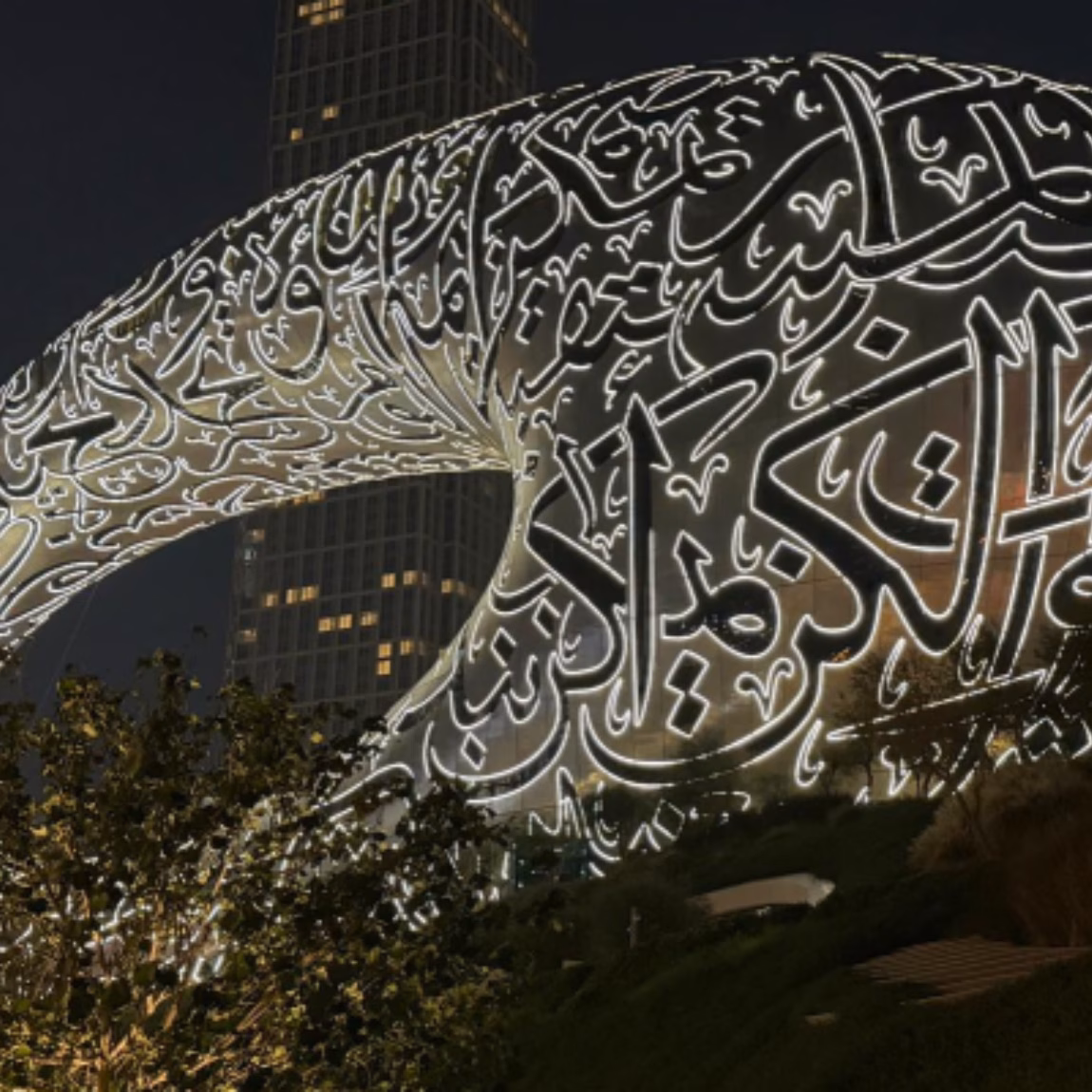 Das Museum der Zukunft in Dubai, dessen markante Fassade nachts von filigranen arabischen Kalligraphie-Motiven beleuchtet wird, symbolisiert Innovation, Technologie, das Wachstum des internationalen Handels und die Entwicklung globaler Märkte.