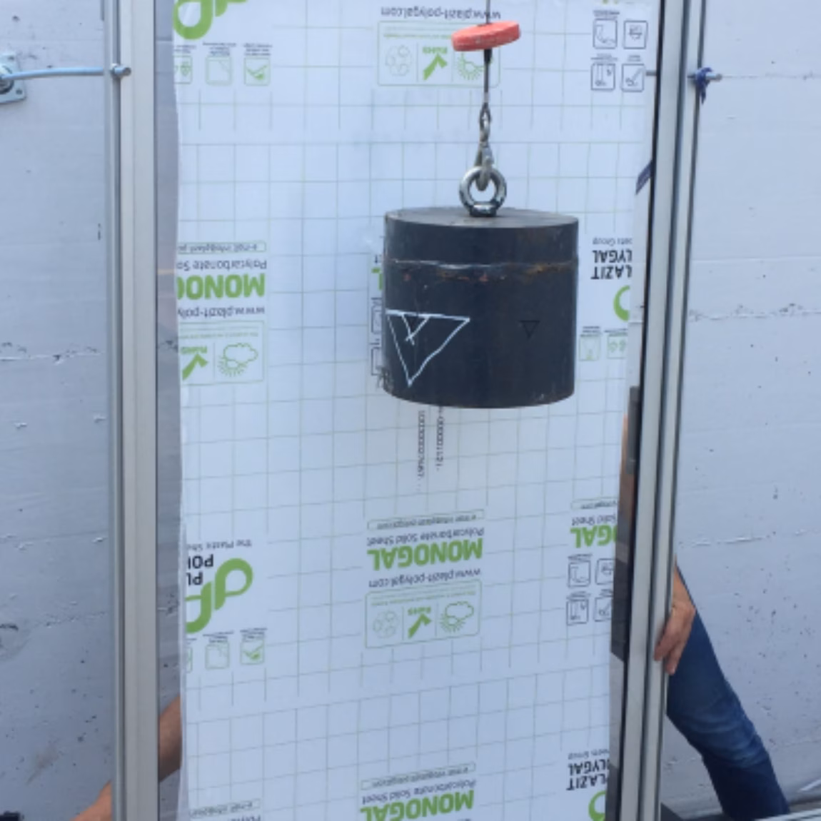 Auf einem speziell für Bauplatten entwickelten Prüfstand wird ein Gewicht aufgehängt, um deren strukturelles Verhalten zu beurteilen, ihre Tragfähigkeit zu prüfen, ihre Haltbarkeit zu bewerten und ihre Qualität in einer kontrollierten Laborumgebung sicherzustellen.