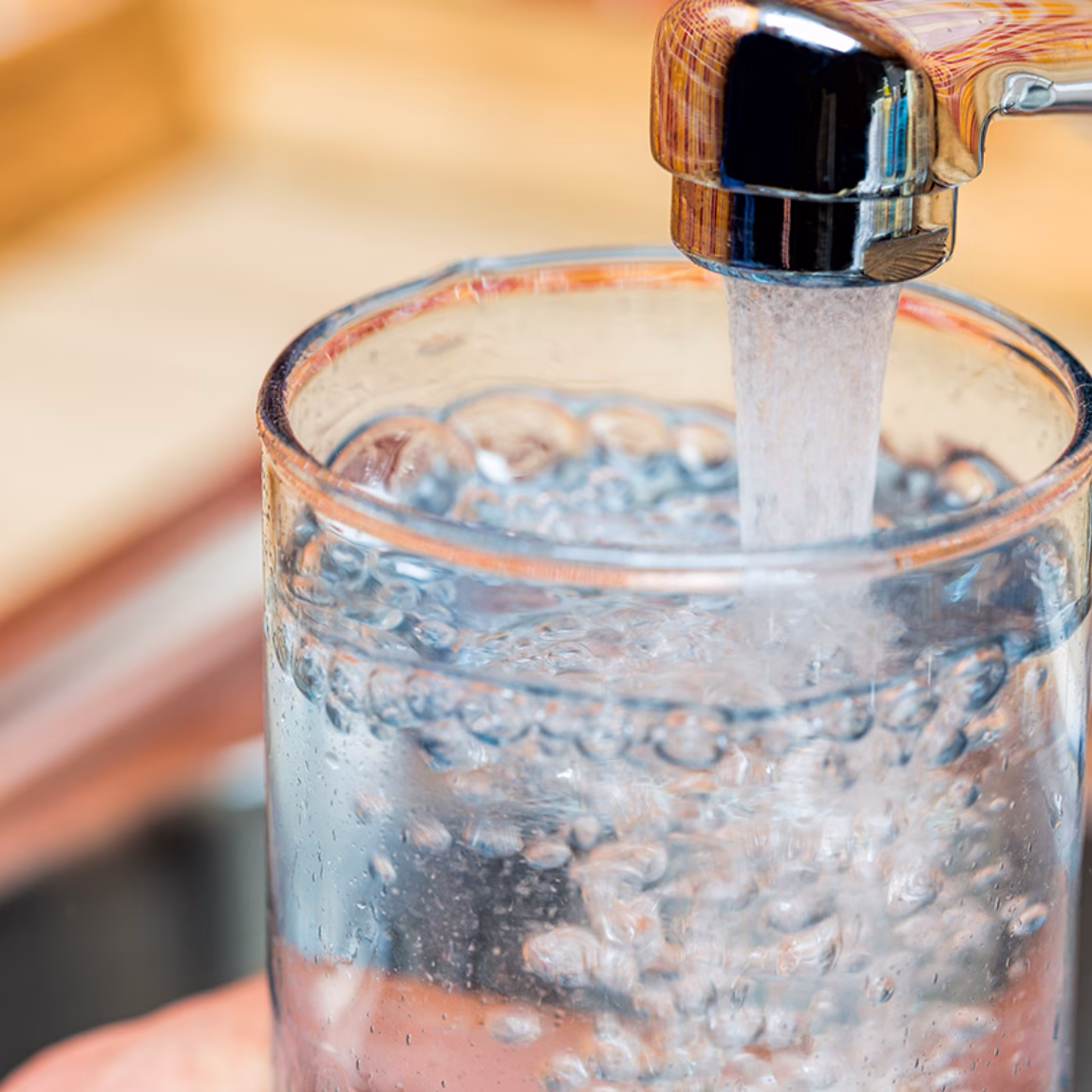 Ein Glas wird im Rahmen des Themas Trinkwassernutzung und Wasserqualität mit Leitungswasser gefüllt.