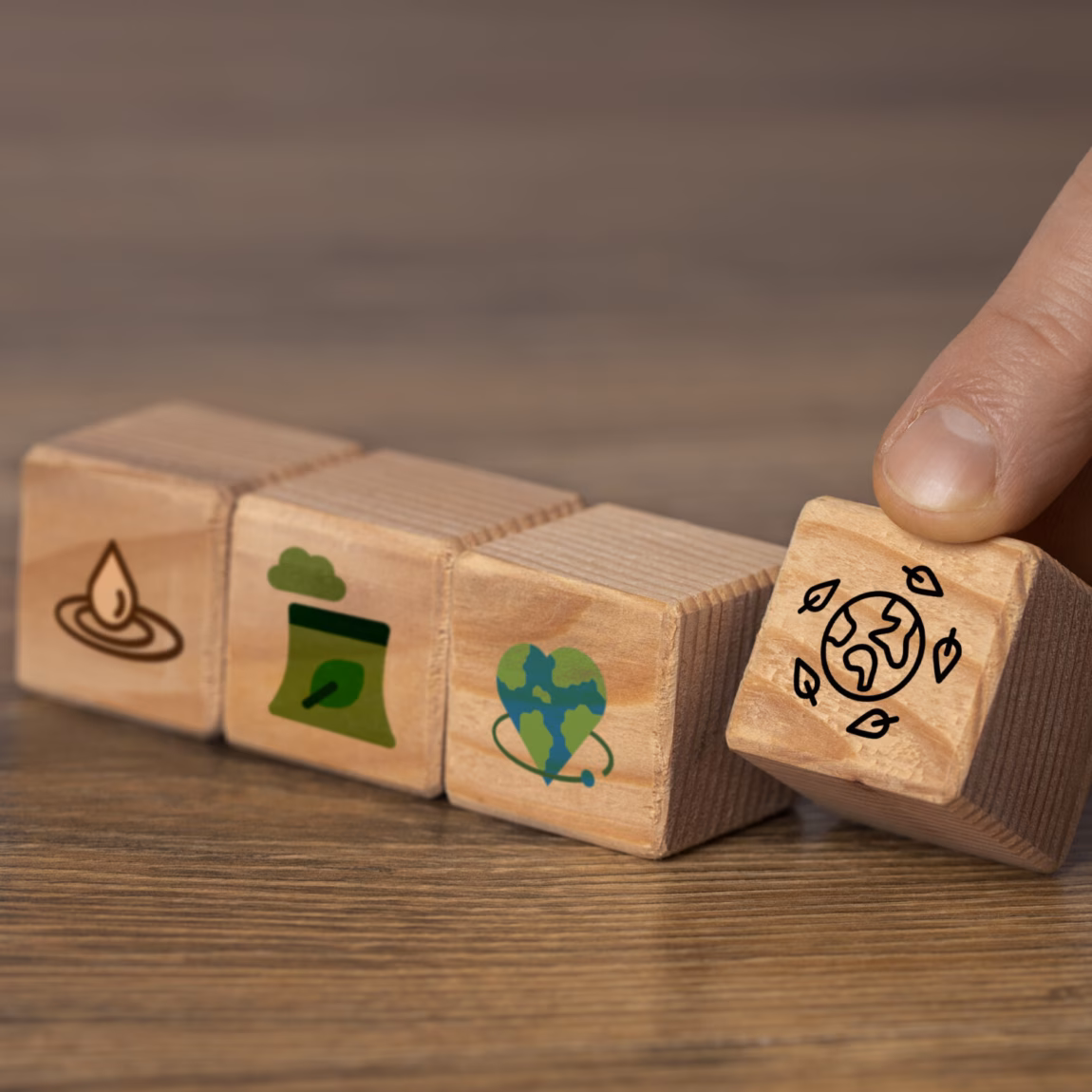 Wooden blocks featuring sustainability symbols illustrate themes related to the environment and corporate social responsibility.