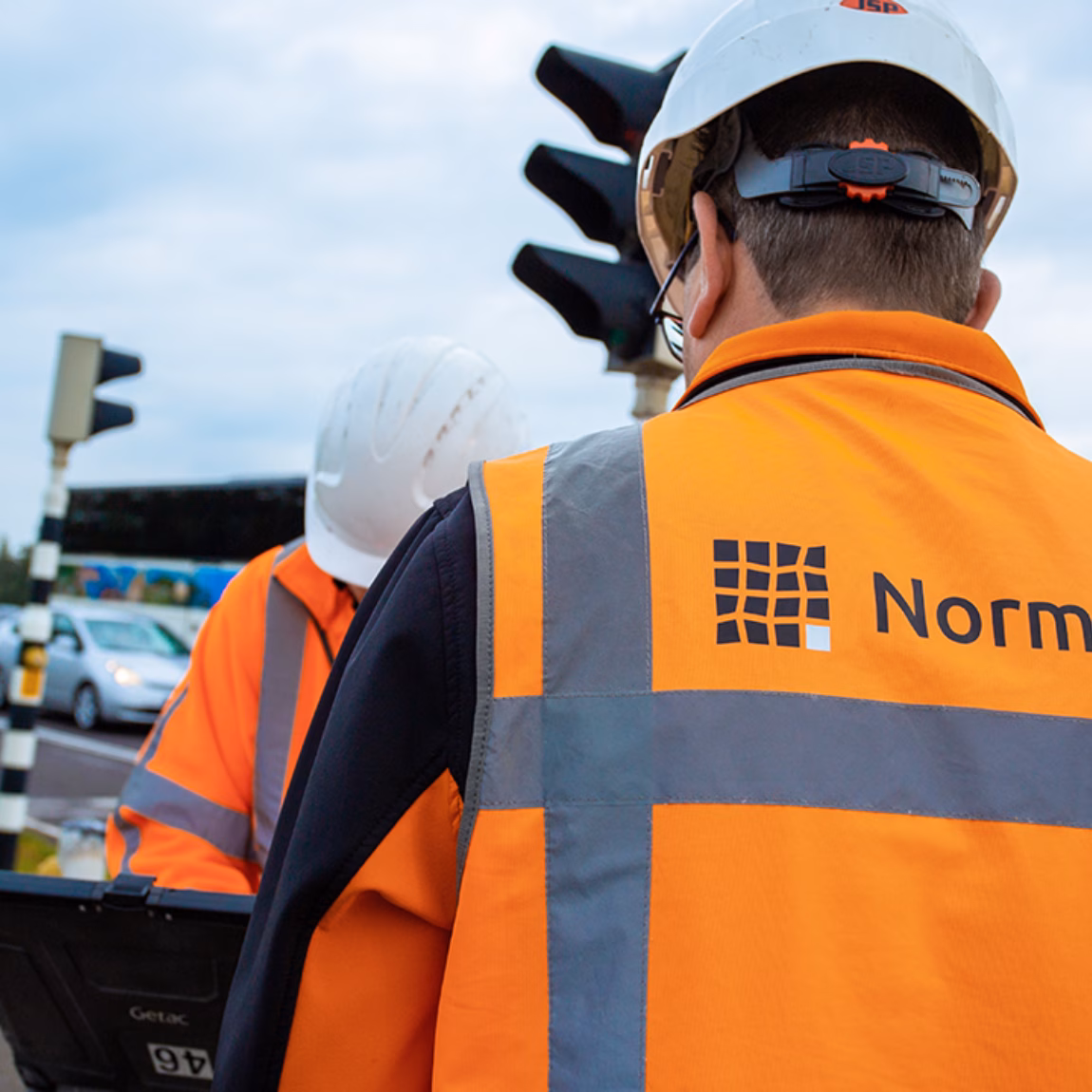 Des employés effectuent des travaux d'inspection technique dans un environnement routier.