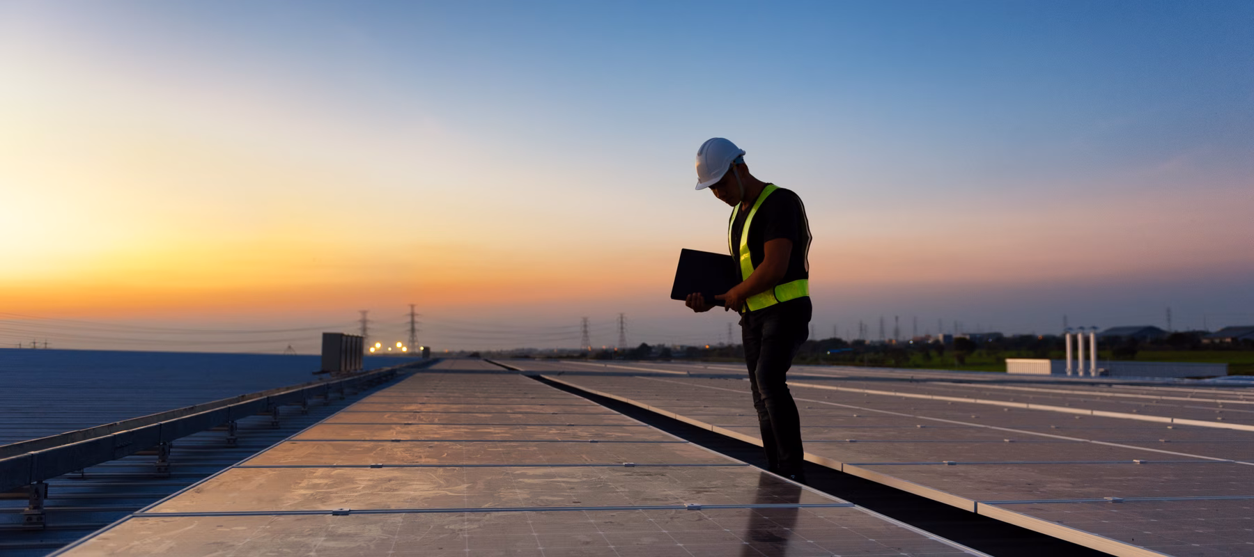 Inspection of solar panels at a solar farm or on a large roof surface using a tablet for monitoring and maintenance.