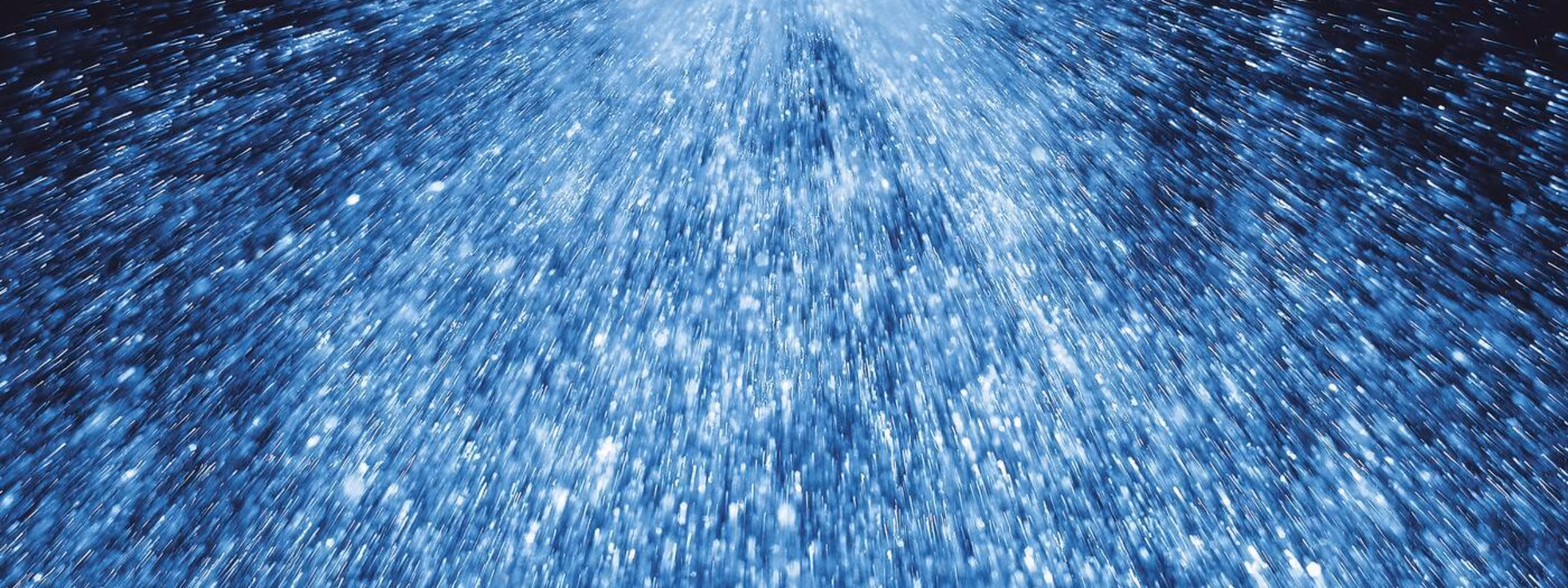 Wassernebel aus einer Sprühdüse während eines industriellen Reinigungs- oder Produktionsprozesses.