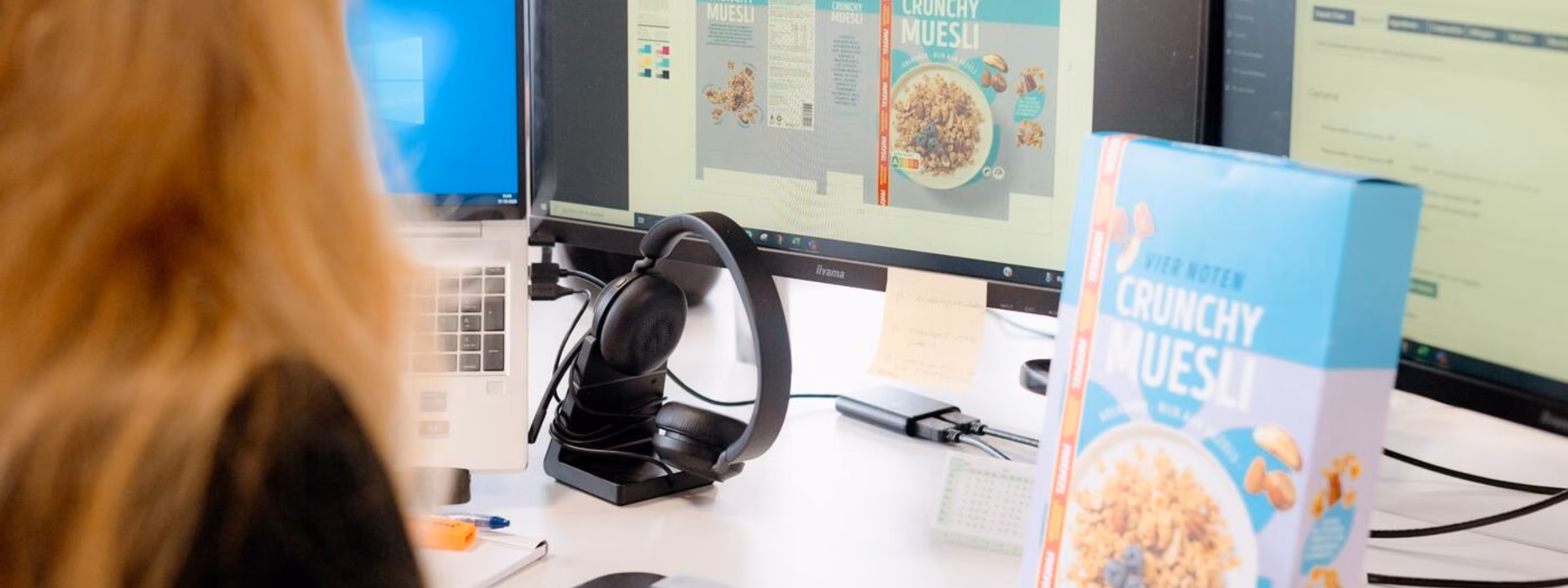 A woman is checking the label of muesli on a computer.