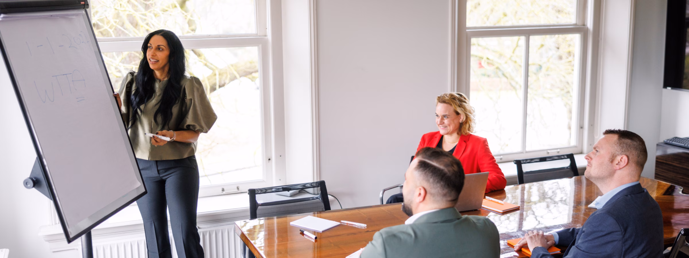Teamoverleg in een kantoorruimte waarbij een presentatie over de WTTA wordt gegeven aan collega’s.