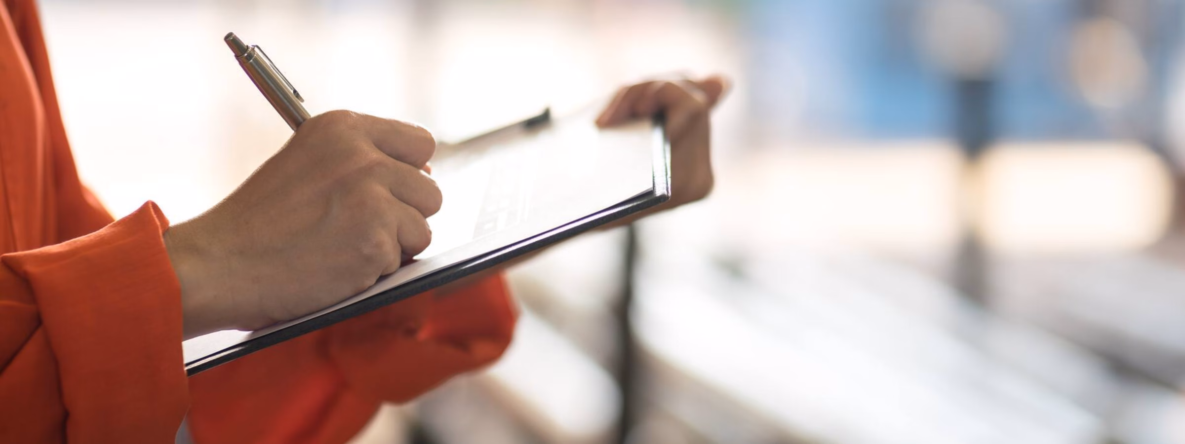An inspector records findings on a clipboard during an audit or field inspection.