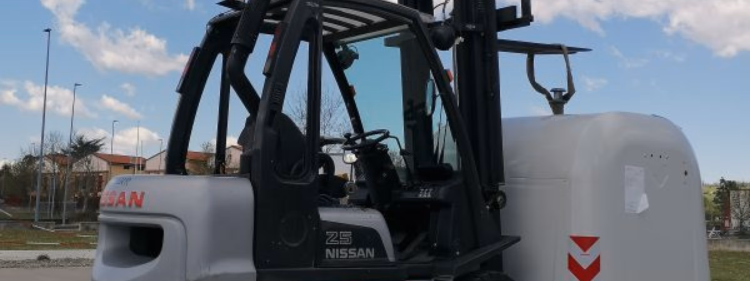 Ein Industriegabelstapler steht neben einer großen Testlast auf einem Testgelände im Freien. Im Vordergrund stehen dabei Sicherheitsbewertungen von Gabelstaplern, die Leistung beim Lastumschlag, die Zertifizierung der Ausrüstung, Stabilitätsprüfungen, die Einhaltung gesetzlicher Vorschriften sowie die Qualitätssicherung für Materialumschlagmaschinen.
