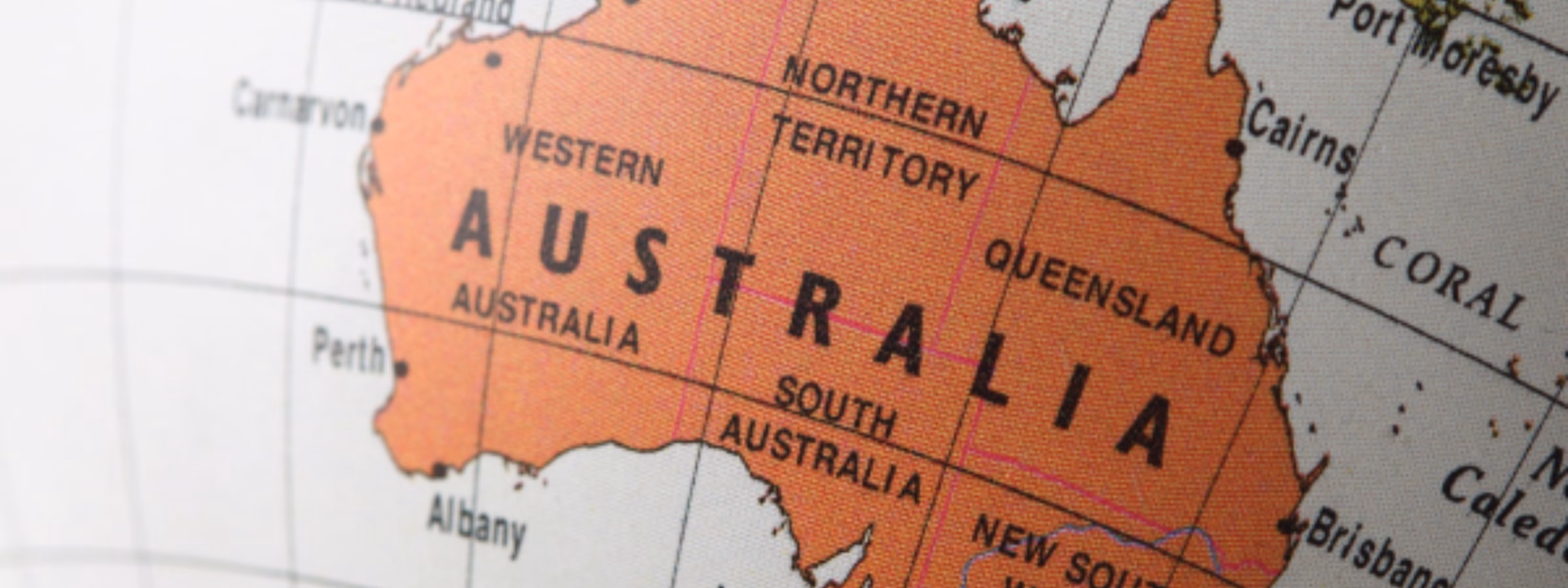 Nahaufnahme einer Weltkarte mit hervorgehobenen Darstellungen von Australien sowie dessen Bundesstaaten und Territorien, die den internationalen Marktzugang, die Einhaltung gesetzlicher Vorschriften, Handelsmöglichkeiten, Produktzertifizierung und Unterstützung bei der Geschäftsexpansion für Unternehmen veranschaulicht, die auf dem australischen Markt tätig sind.