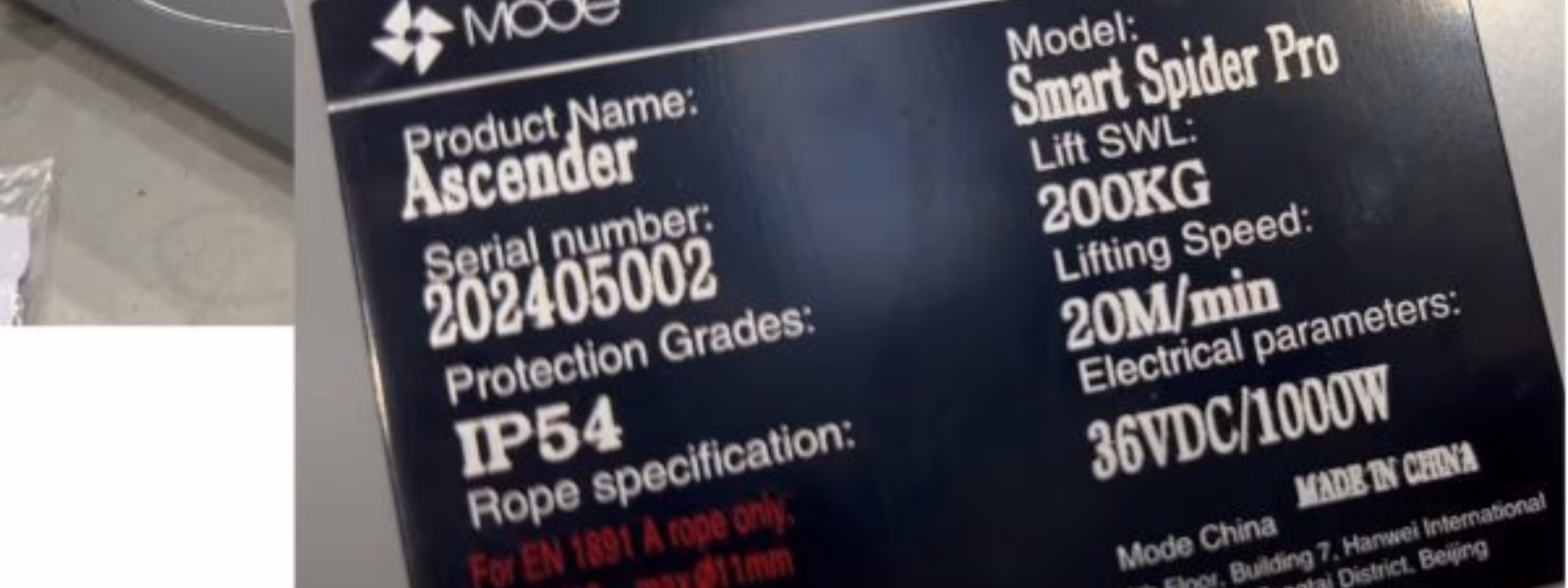 Nahaufnahme eines Produktkennzeichnungsetiketts an einer Industrieanlage, das technische Spezifikationen, die Schutzart IP54, die Tragkraft, die Seriennummer und die CE-Kennzeichnung zeigt und damit die Rückverfolgbarkeit des Produkts, die Einhaltung gesetzlicher Vorschriften, Zertifizierungsanforderungen sowie die Qualitätssicherung für Industrie- und Hebezeuge verdeutlicht.