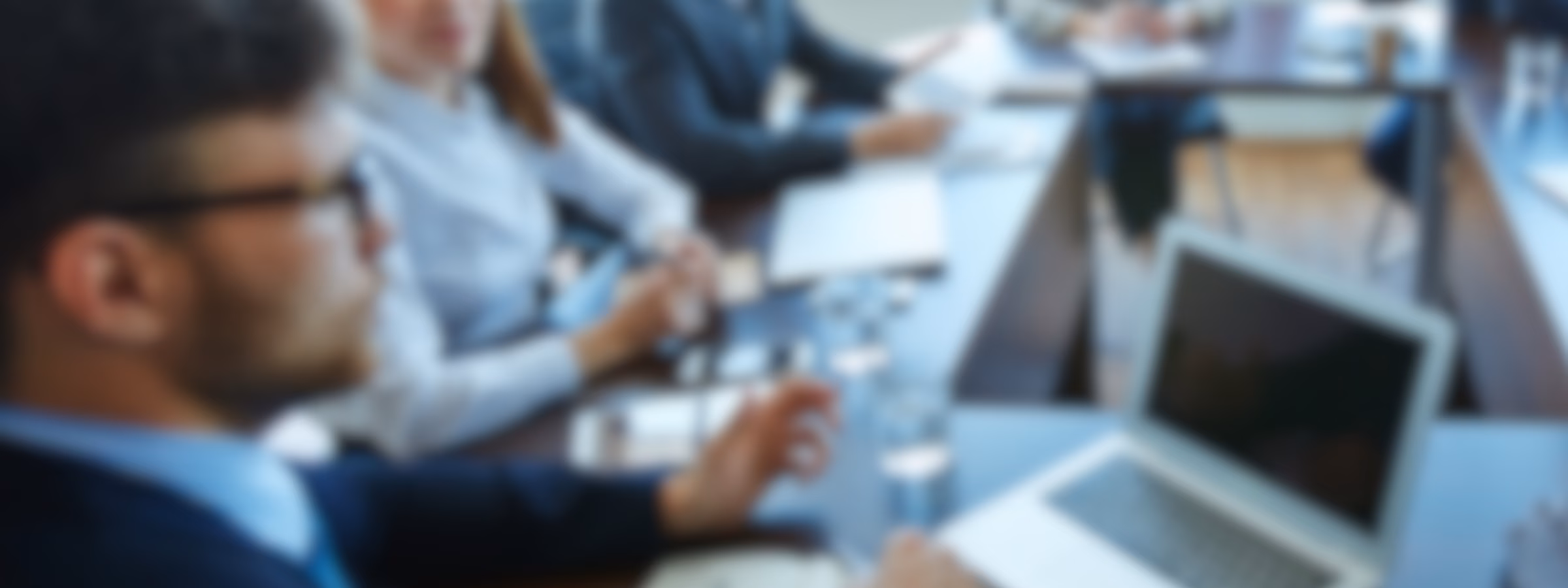 Fachleute nehmen an einer Besprechung am Konferenztisch teil, ausgestattet mit Laptops und Unterlagen. Im Vordergrund stehen Unternehmensberatung, strategische Planung, Einbindung von Interessengruppen, Projektmanagement und effektive Teamarbeit im Unternehmensumfeld.