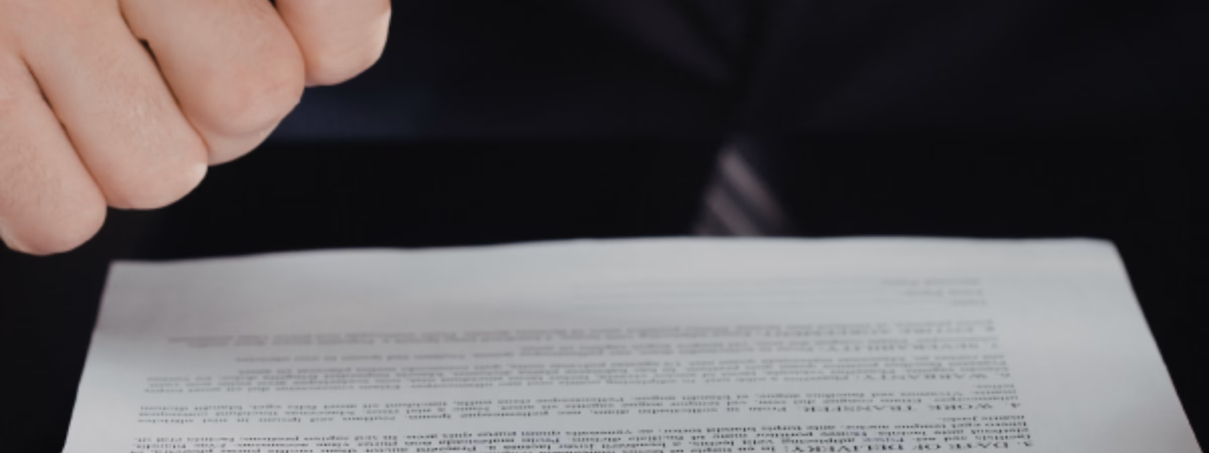 Eine Lupe wird zur Prüfung eines gedruckten Dokuments verwendet, wobei die Schwerpunkte auf der Einhaltung gesetzlicher Vorschriften, der Dokumentenprüfung, der Qualitätssicherung, der Auditierung, der Risikobewertung sowie der detaillierten Bewertung technischer und behördlicher Unterlagen liegen.