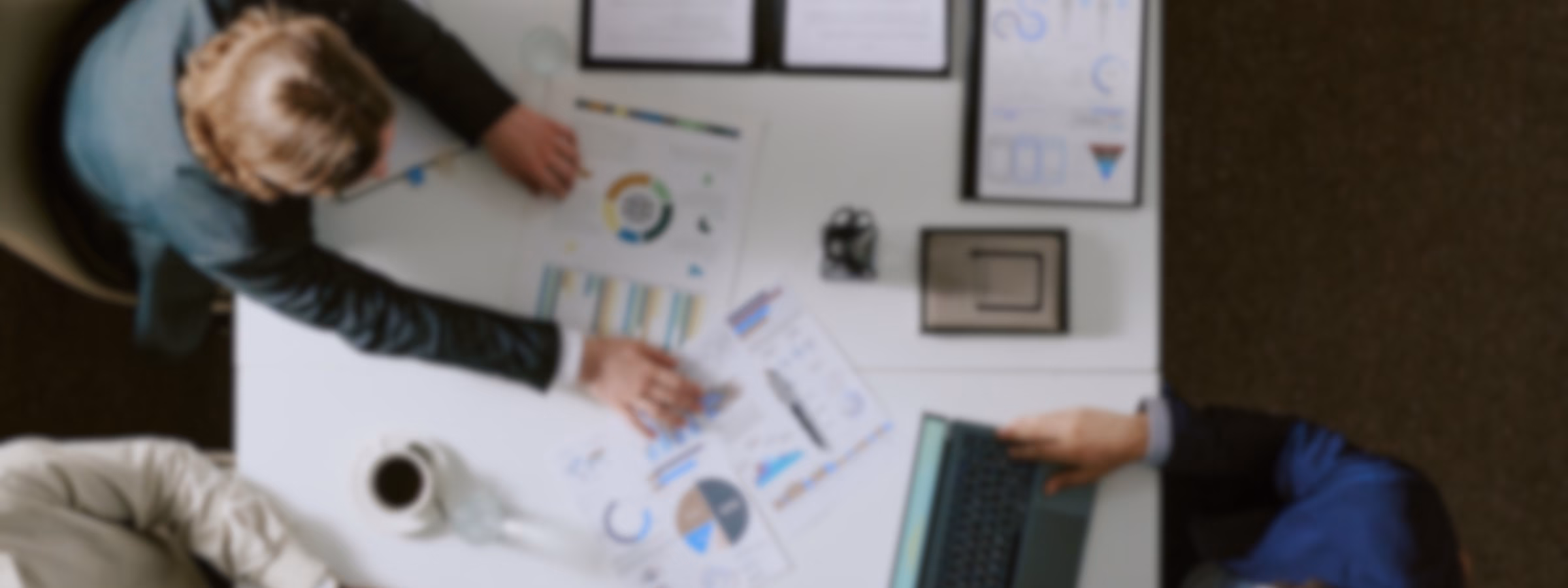 Fachleute sitzen gemeinsam am Besprechungstisch und prüfen Diagramme, Leistungsberichte und Geschäftsdaten, wobei der Schwerpunkt auf strategischer Planung, Datenanalyse, Projektmanagement und fundierter Entscheidungsfindung in einem modernen Unternehmensumfeld liegt.