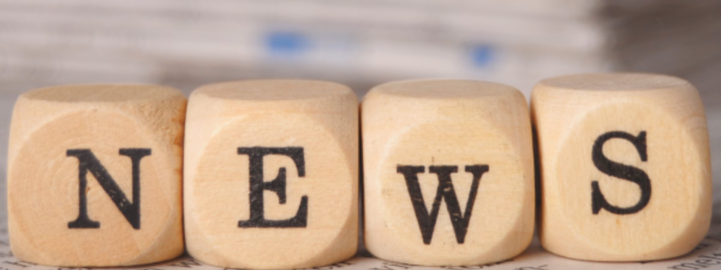 Holzbuchstaben, die vor einem Zeitungshintergrund das Wort „NEWS“ bilden, symbolisieren Unternehmensnachrichten, Branchenentwicklungen, Führungskräfte, Geschäftsanalysen und die neuesten Nachrichten über das Unternehmen.