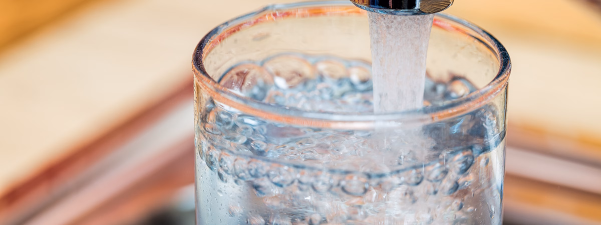 Ein Glas wird im Rahmen des Themas Trinkwassernutzung und Wasserqualität mit Leitungswasser gefüllt.