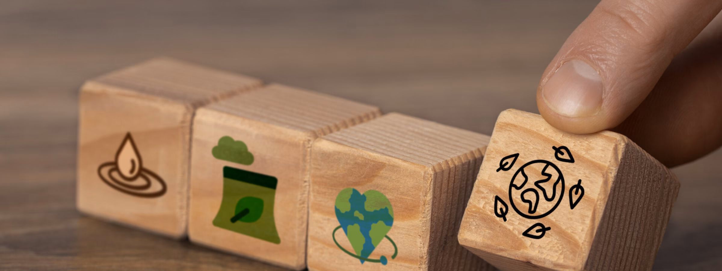 Wooden blocks featuring sustainability symbols illustrate themes related to the environment and corporate social responsibility.