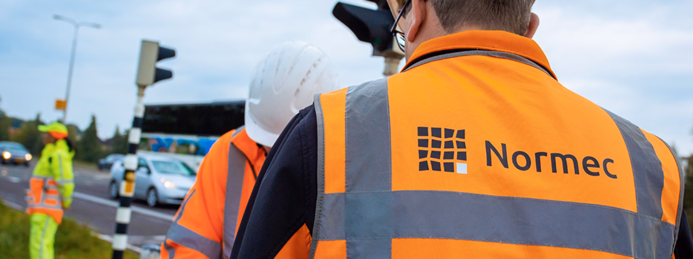 Des employés effectuent des travaux d'inspection technique dans un environnement routier.