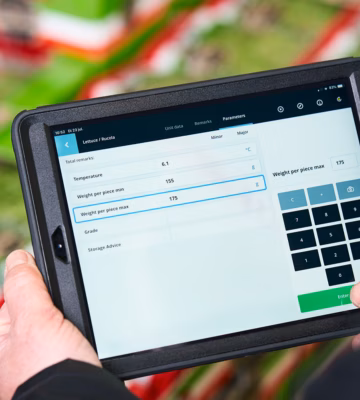 Een man gebruikt een iPad met kwaliteitscontrole (QC) software, terwijl hij gegevens controleert en analyseert.