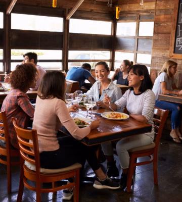 Des clients sont assis à table et mangent dans un restaurant à l'ambiance décontractée.