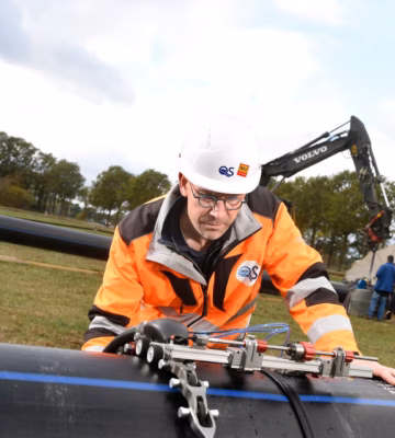 Ein technischer Mitarbeiter führt mit speziellen Messgeräten eine Schweißnahtprüfung an einer Rohrleitung durch.