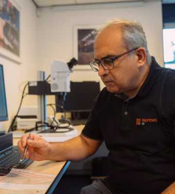 Der Mitarbeiter führt an einem Arbeitsplatz präzise Messungen oder Analysen mit Laborgeräten durch.