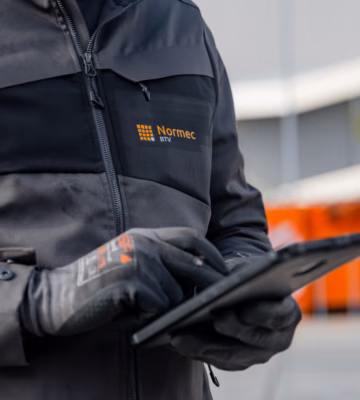 Close-up of an industrial inspector using a tablet to record inspection results and compliance data, highlighting digital inspections, asset management, regulatory compliance, quality assurance, and efficient reporting processes for industrial equipment and workplace safety assessments.