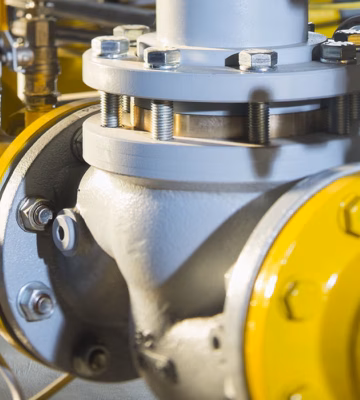Industriële gasleidingen met flenzen en sensoren voor het controleren en verminderen van gasemissies.