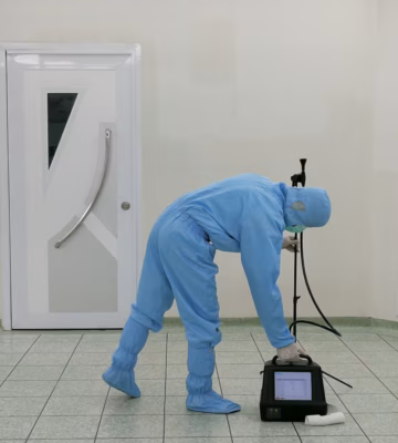 Medewerker in cleanroomuitrusting voert luchtkwaliteitsmeting en hygiënisch onderzoek uit