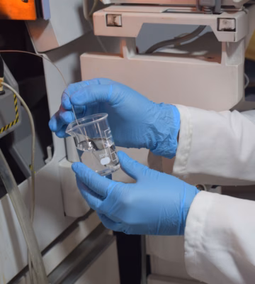 Un échantillon d'eau est examiné en laboratoire afin d'analyser la qualité de l'eau et les paramètres microbiologiques.