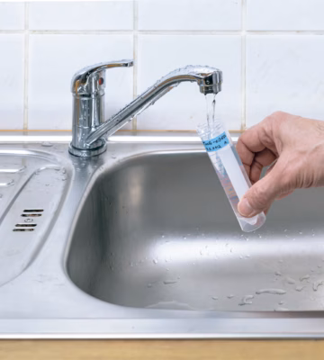 Un échantillon d'eau est prélevé au robinet en vue d'une analyse de la qualité de l'eau.