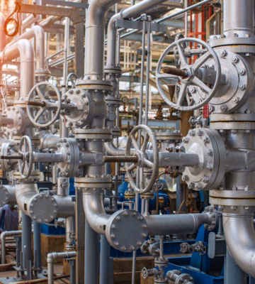 Les canalisations et les vannes font partie d'une installation industrielle destinée au transport et au traitement de liquides ou de gaz.