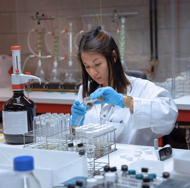 Laboratoriummedewerker voert een analyse uit met een pipet en reageerbuisjes in een onderzoekslaboratorium.