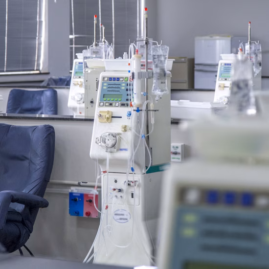 Een behandelruimte in een zorginstelling met meerdere dialysemachines naast comfortabele behandelstoelen. De apparatuur staat opgesteld voor het uitvoeren van dialysebehandelingen en het monitoren van patiënten tijdens de behandeling. De ruimte oogt schoon, modern en professioneel ingericht.