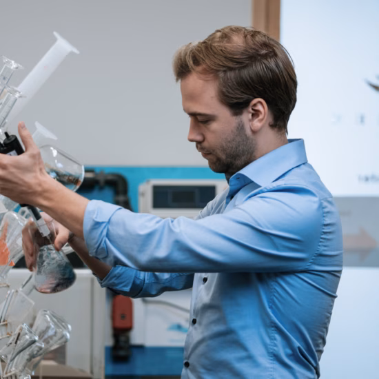 A man is testing Erlenmeyer flasks in a laboratory.