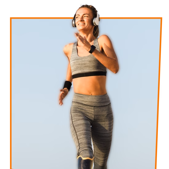 Smiling woman running outdoors wearing headphones.