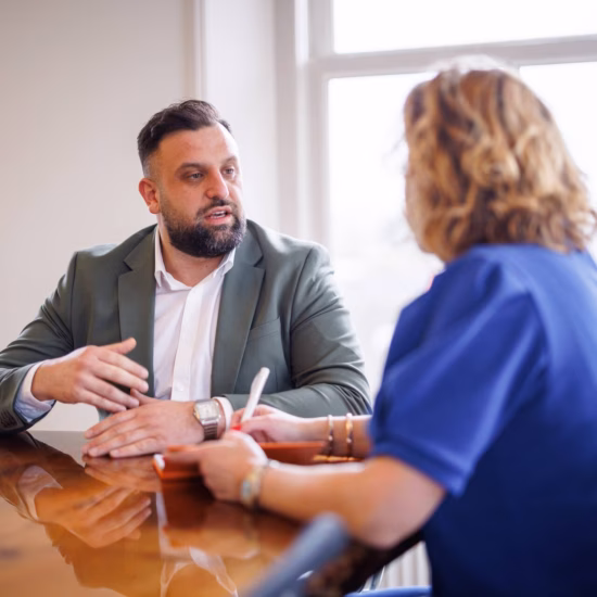 Two people talking at a conference table during a business meeting.