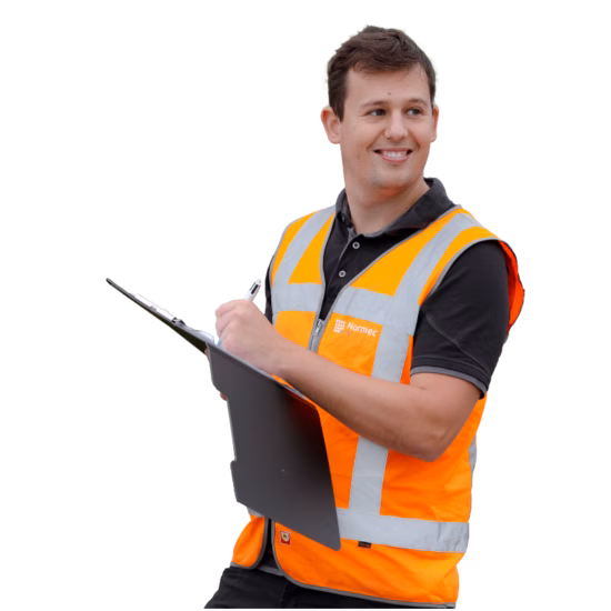 A smiling man is wearing a safety vest and holding a pen and notepad.