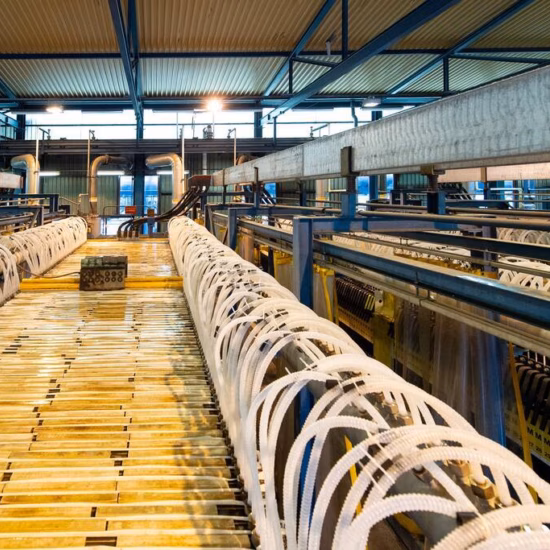 Industrial production line with metal frames and tubes in a metalworking factory.