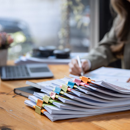 Business Documents concept : Businesswoman working in Stacks of paper files for searching and checking unfinished document achieves on folders papers