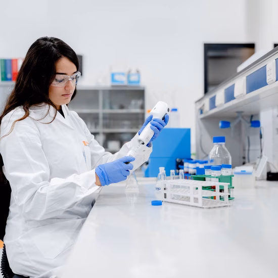 Laboratoriummedewerker voert een vloeistofanalyse uit met een pipet in een modern onderzoekslaboratorium.