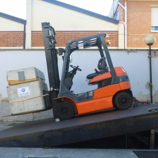 Ein Industriegabelstapler, der einen beladenen Container transportiert, wird auf einer geneigten Testplattform positioniert, um in einer kontrollierten Testumgebung die Fahrzeugstabilität, die Lastumschlagleistung, die Sicherheitsbewertung des Gabelstaplers, die Betriebssicherheit sowie die Einhaltung der Normen für Industrieausrüstung zu demonstrieren.