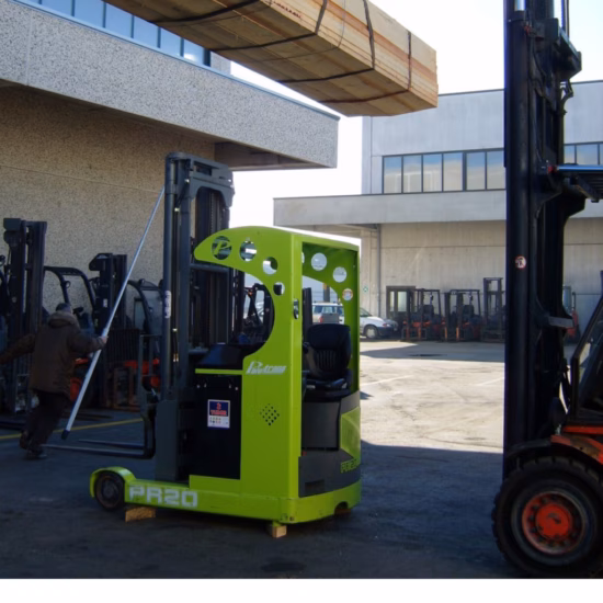 Ein kompakter Industriestapler fährt unter einer hängenden Last aus Holzmaterialien auf einem Lagerhof und veranschaulicht dabei sichere Hebeverfahren, Materialumschlagvorgänge, Arbeitssicherheit, logistische Effizienz und qualitätskontrollierte industrielle Transportprozesse.