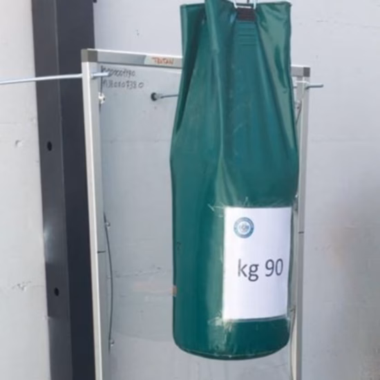 Ein 90-kg-Prüfsack wird in einer Laborprüfanlage aufgehängt, um die Festigkeit, Tragfähigkeit und Haltbarkeit der Materialien zu bewerten und deren Qualität in einer kontrollierten Prüfumgebung sicherzustellen.